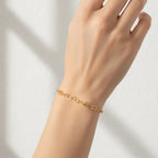 Gold bracelet on a hand against a light background