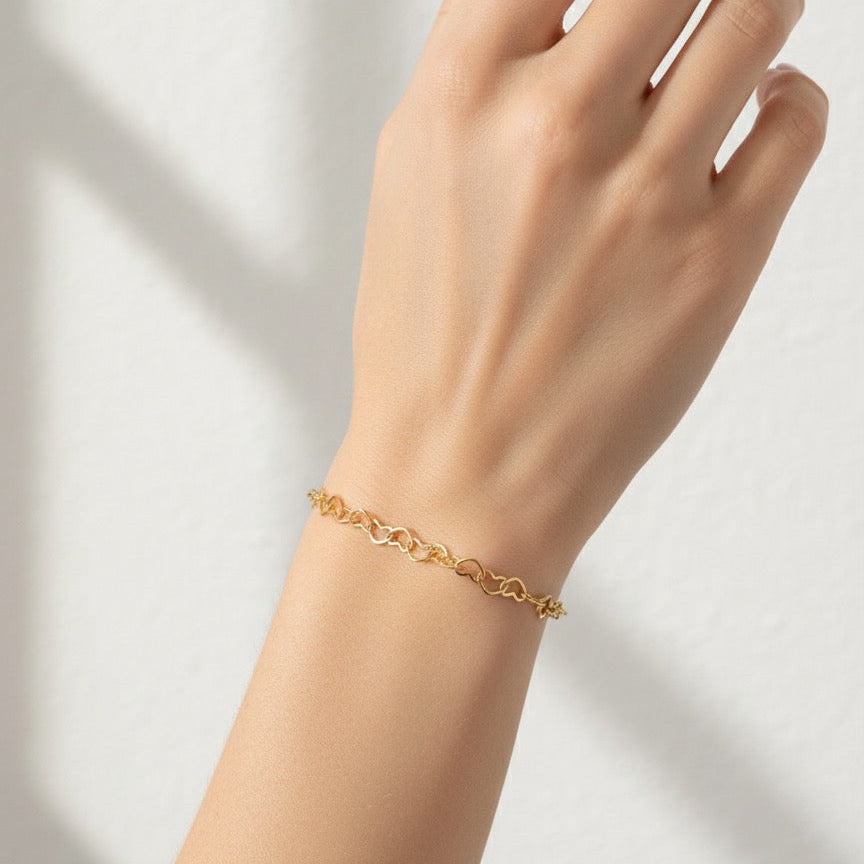 Gold bracelet on a hand against a light background