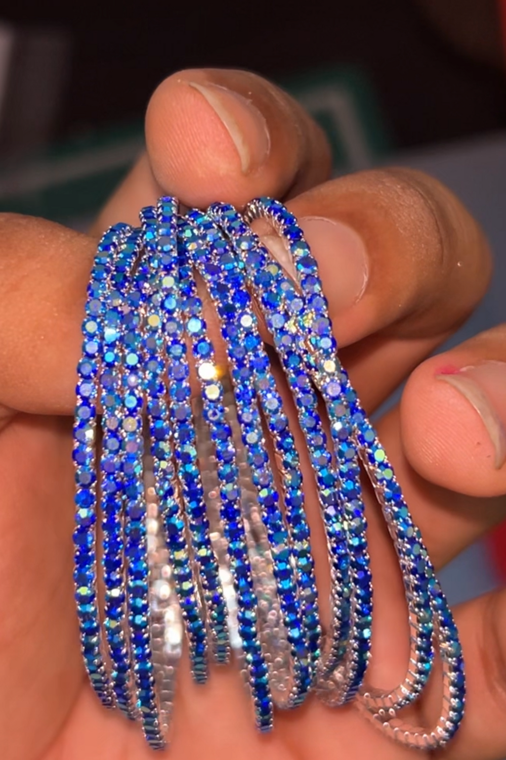 Blue and silver beaded bracelets on a hand with a blurred background